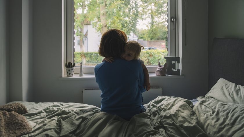 a mother holds her baby in a dark room