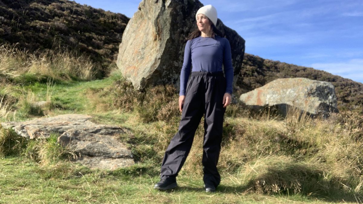 A hiker standing in front of a large boulder