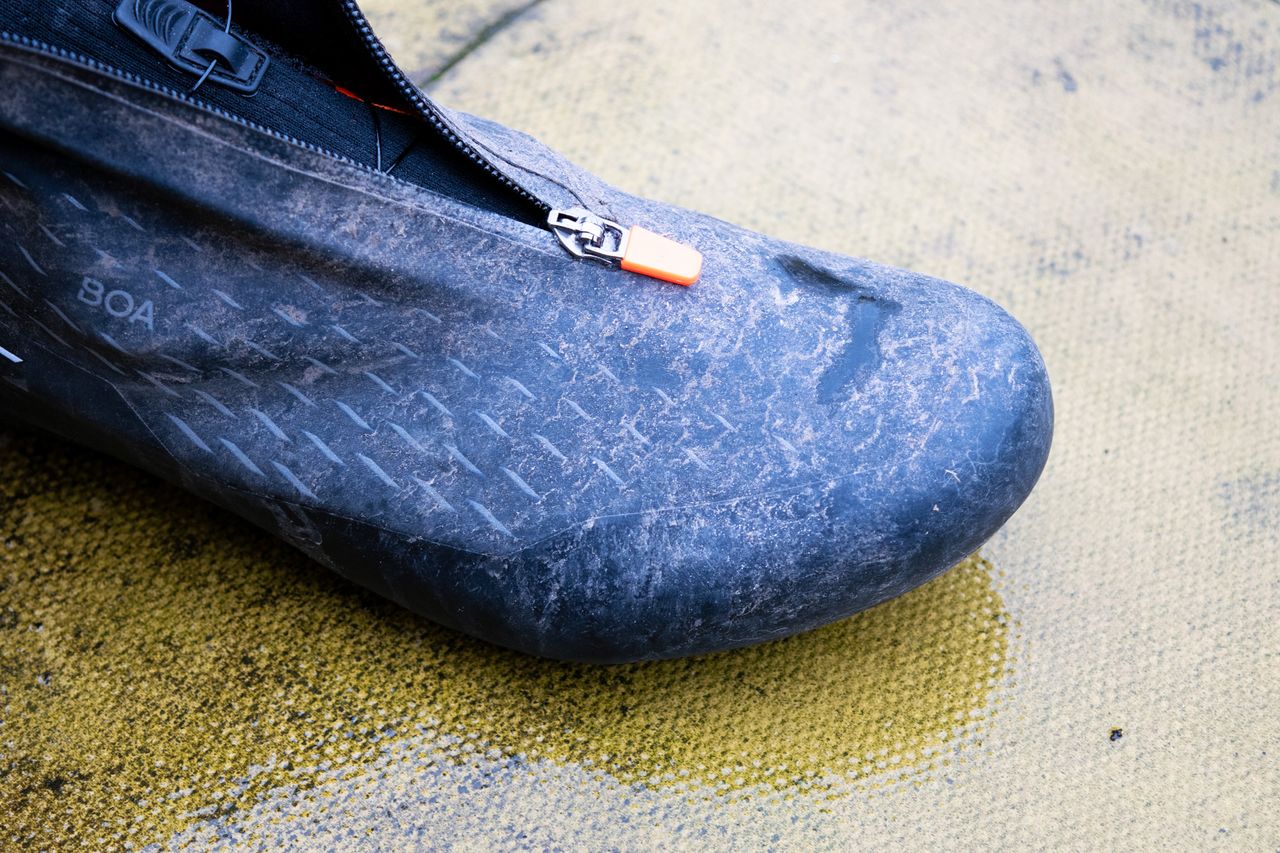 A dirty DMT WKR1 cycling shoe on a patio