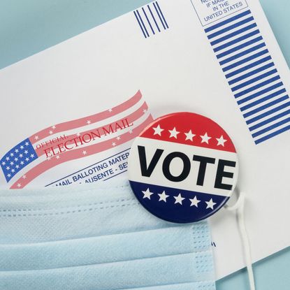 Envelope with ballot inside, election pin and face mask