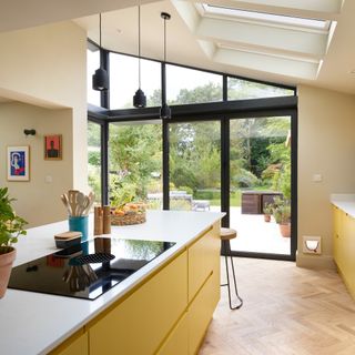 a yellow kitchen with patio doors and skylights