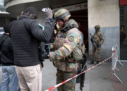 Belgian security forces check bags oustide a metro stop