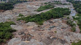 Here we see an overhead view of the gold mining activities taking place in the Napo province, Ecuador. You can see a number of yellow construction vehicles used for digging.