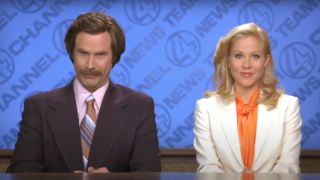 Will Ferrell smirks next to a smiling Christina Applegate in Anchorman The Legend of Ron Burgundy.