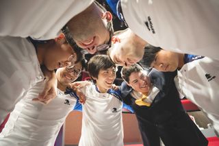 UCI League of Legends head coach James Bates and team huddle before the LoL College Championship 2019 finals.