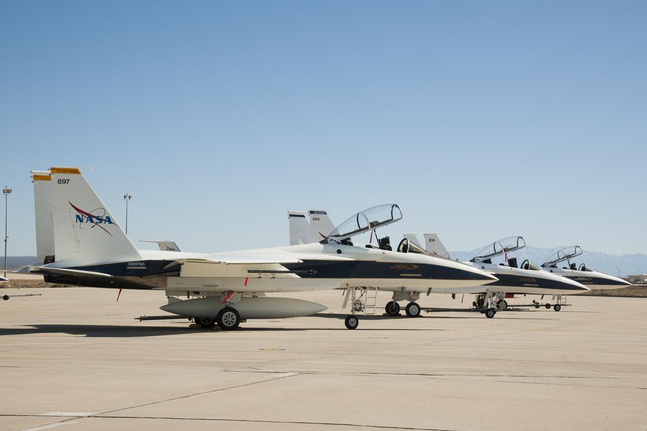 three white fighter jets on a runway in the desert