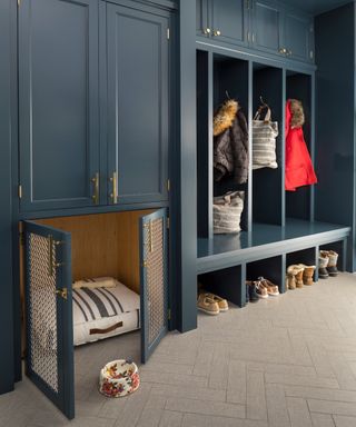 mudroom with full height navy blue storage with cupboards, pet bed, and stalls with wall hooks - MurphyCoDesign