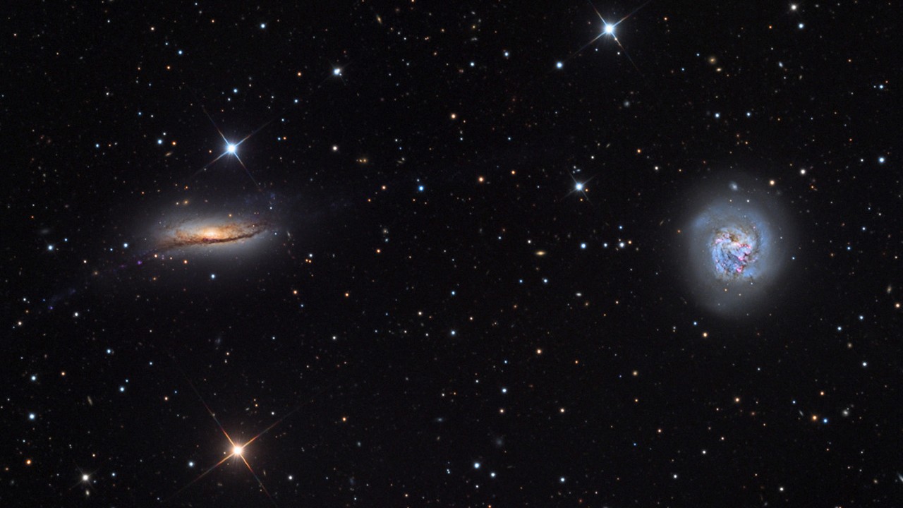 two swirls of colorful light on a starry background