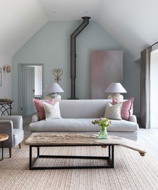 Neutral rustic living room with pops of pink in luxurious Cotswolds barn