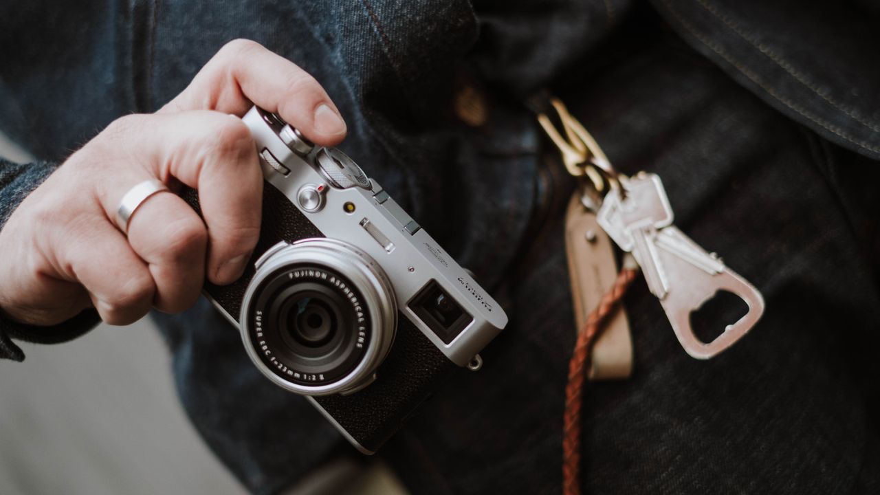 A man holding one of the best camera for beginners – the Fujifilm X100V