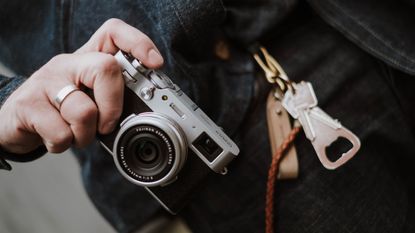 A man holding one of the best camera for beginners – the Fujifilm X100V