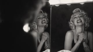 Ana de Armas looks at her smiling reflection as Marilyn Monroe in Blonde