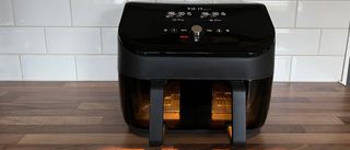The Instant Vortex Plus Dual Drawer Air Fryer with the light on so youcan keep an eye on the progress of what you're cooking