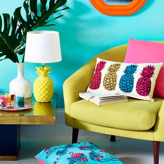 room with blue wall armchair and pineapple lamp