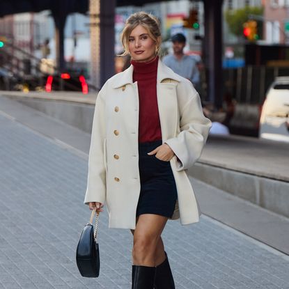 woman wearing turtleneck, collared jacket, boots, and skirt