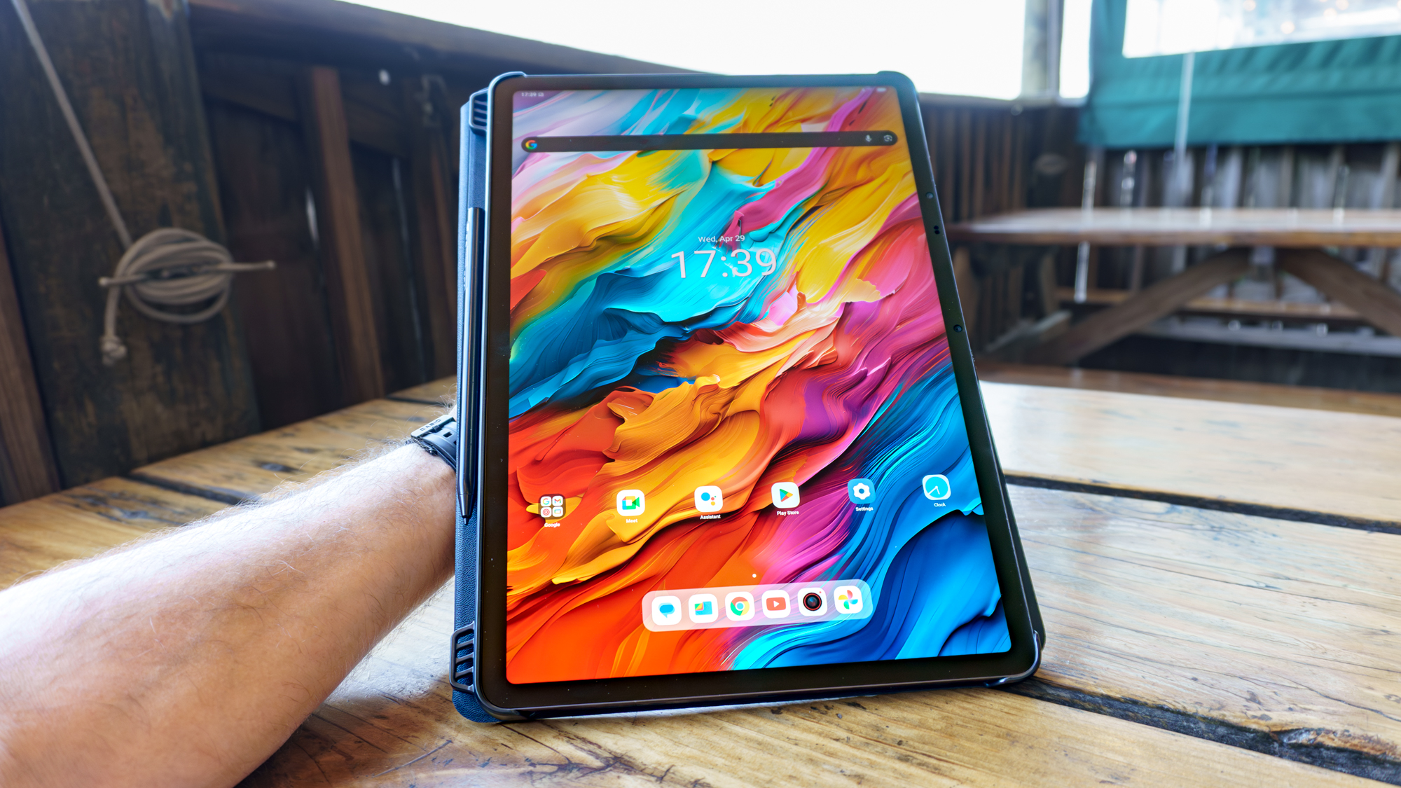 A person holding the TCL NXTPAPER 14 tablet at a table