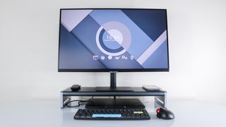 A monitor on top of and a laptop under the Anker 675 docking station on a desk