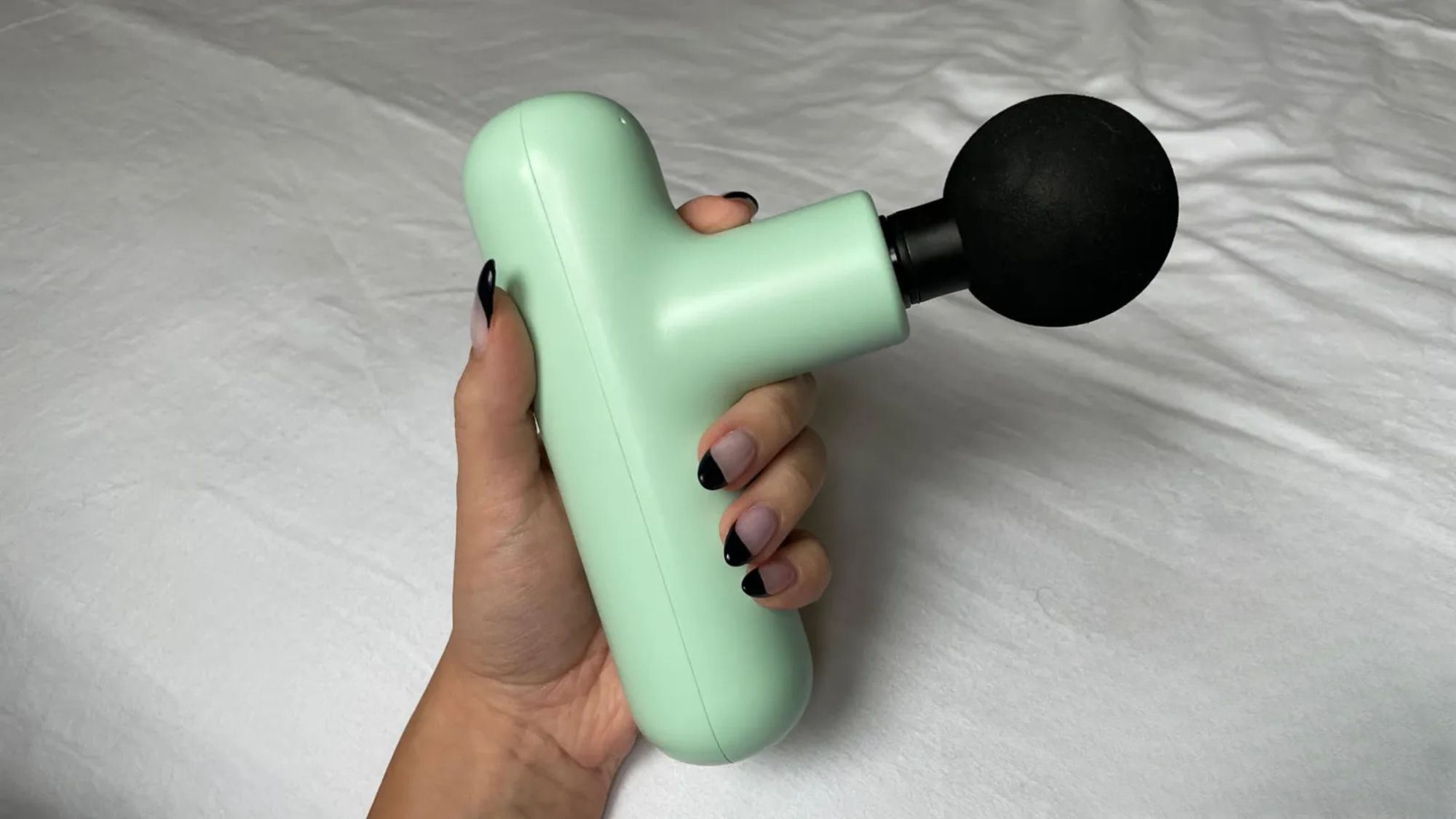 best massage guns: valeza holding one of the guns tested by marie claire uk