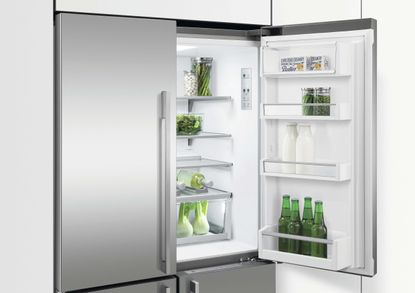 open fridge with green bottles in the door