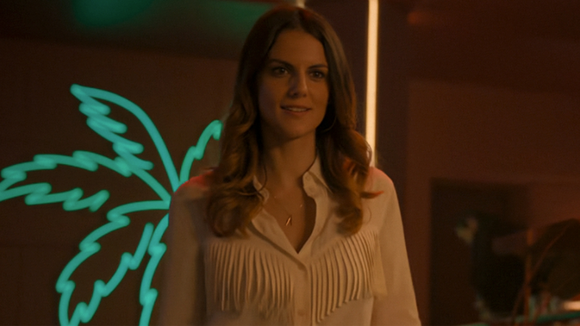 A woman smiling and wearing a white shirt in More the Merrier