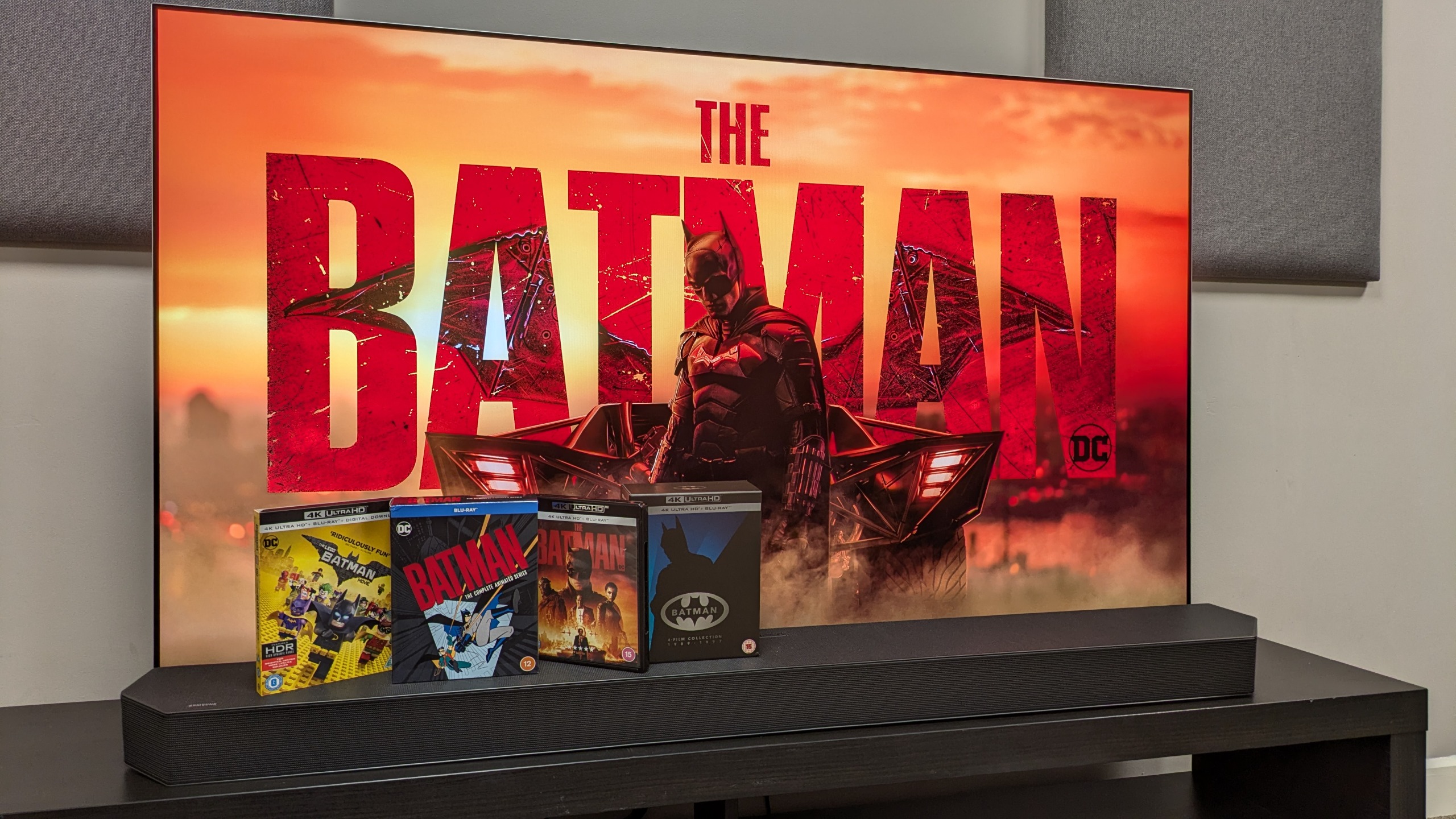 Shot of The Batman resume screen on LG G6 with various Batman 4K Blu-ray discs in front of screen 