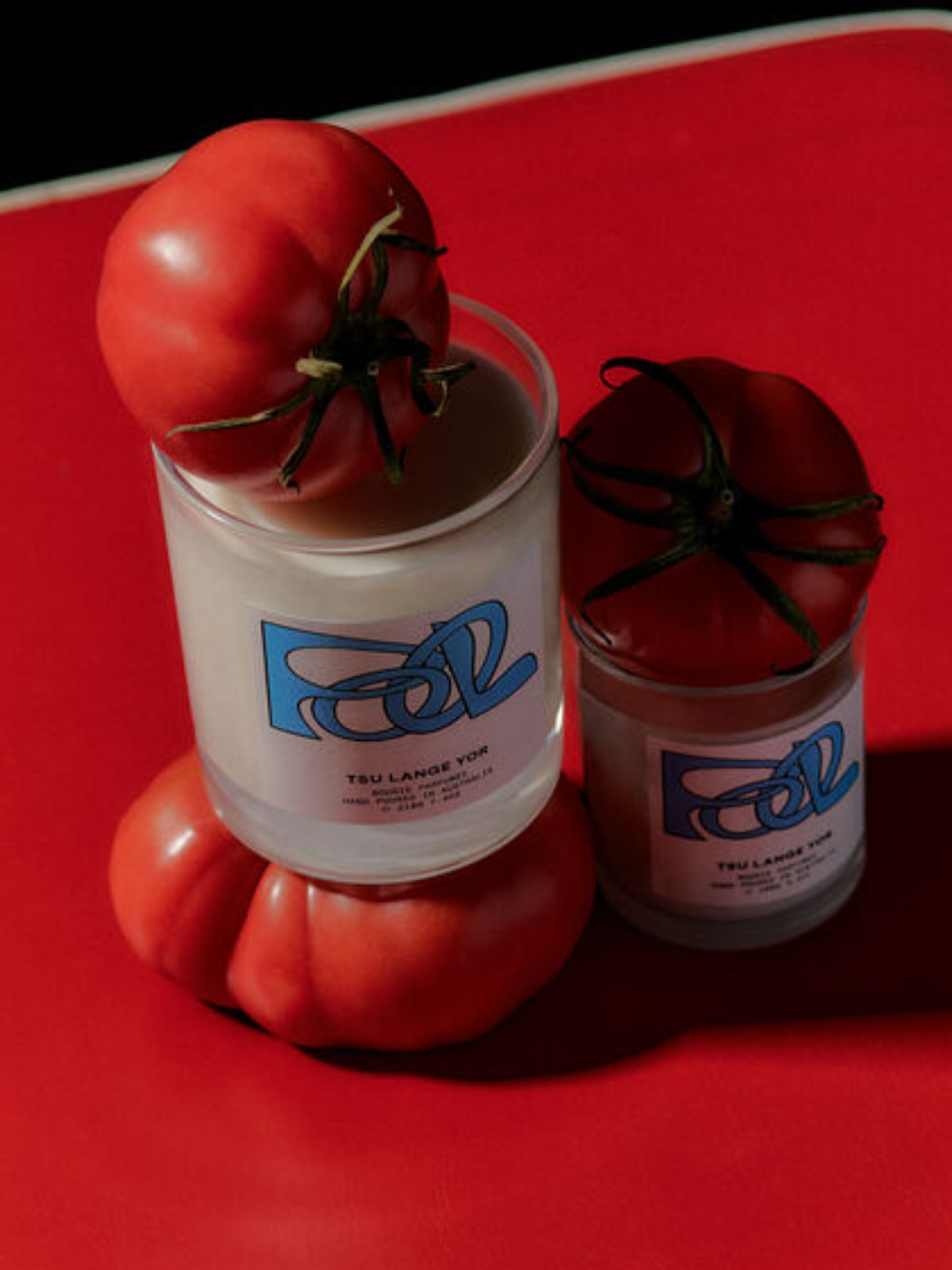 A glass candle styled with tomatoes from Tsu Lange Yor