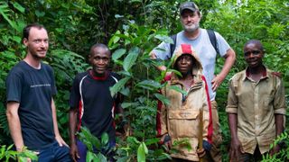 Dr. Vincent Deblauwe from the Congo Basin Institute (left) and Scott Paul (back) pose with Cameroon workers while planting ebony trees in the rainforest.