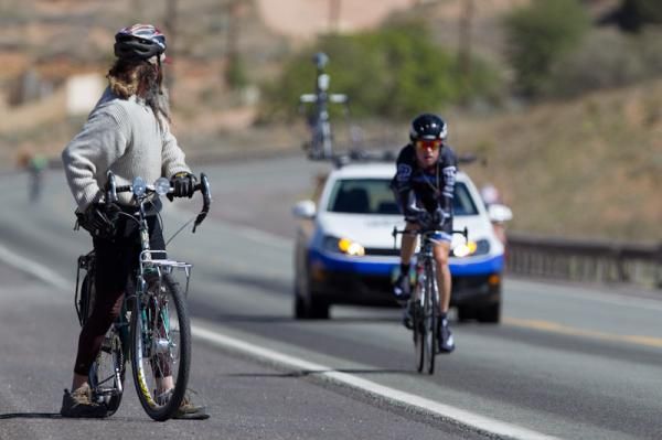 A fan watches as riders come up the course.