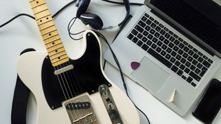 White Fender Telecaster next to a laptop