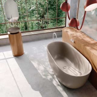 Light-filled bathroom with light floor and large freestanding grey bath