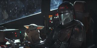 Mandalorian and Baby Yoda sitting in the cockpit of a ship