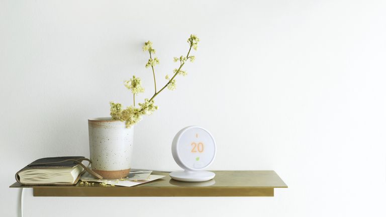 Best smart thermostat 2021, Nest Smart Thermostat E with stand on side table, next to a plant and notebook