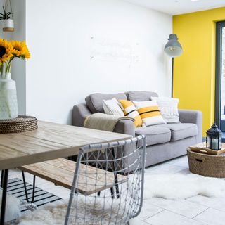 living room with grey sofa and white and yellow wall