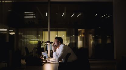 Businessman concentrating while working overtime in the office late at night