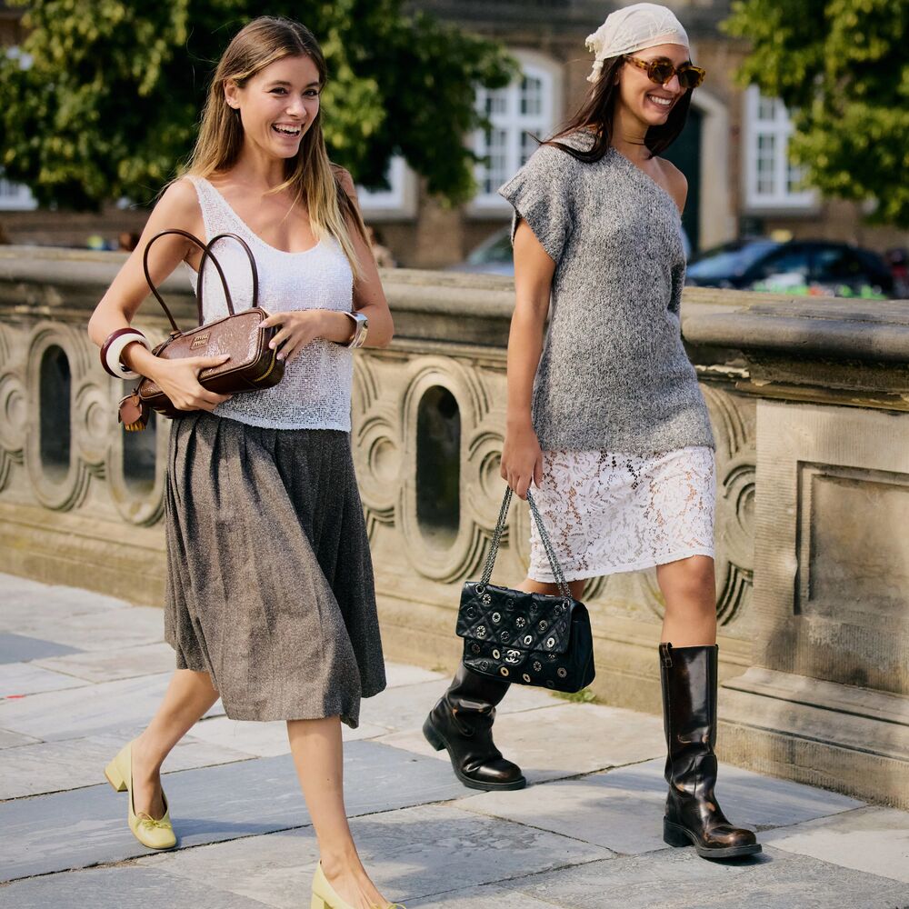Women walk and pose in Copenhagen. One wears a white tank, plaid skirt, and flat pumps. The other wears a lace skirt, t-shirt, boots, and lace.