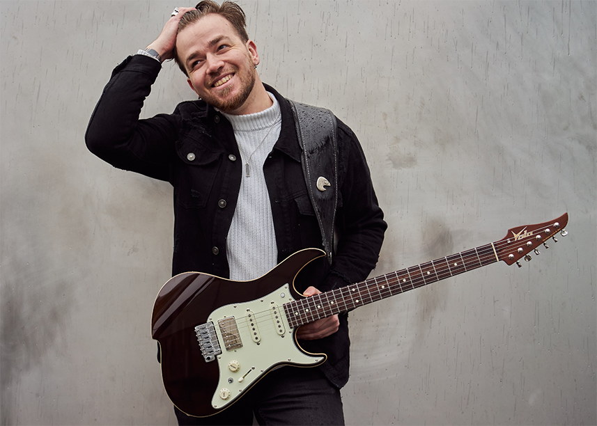 Quentin Godet holds his new Vola signature QGM J2 guitar