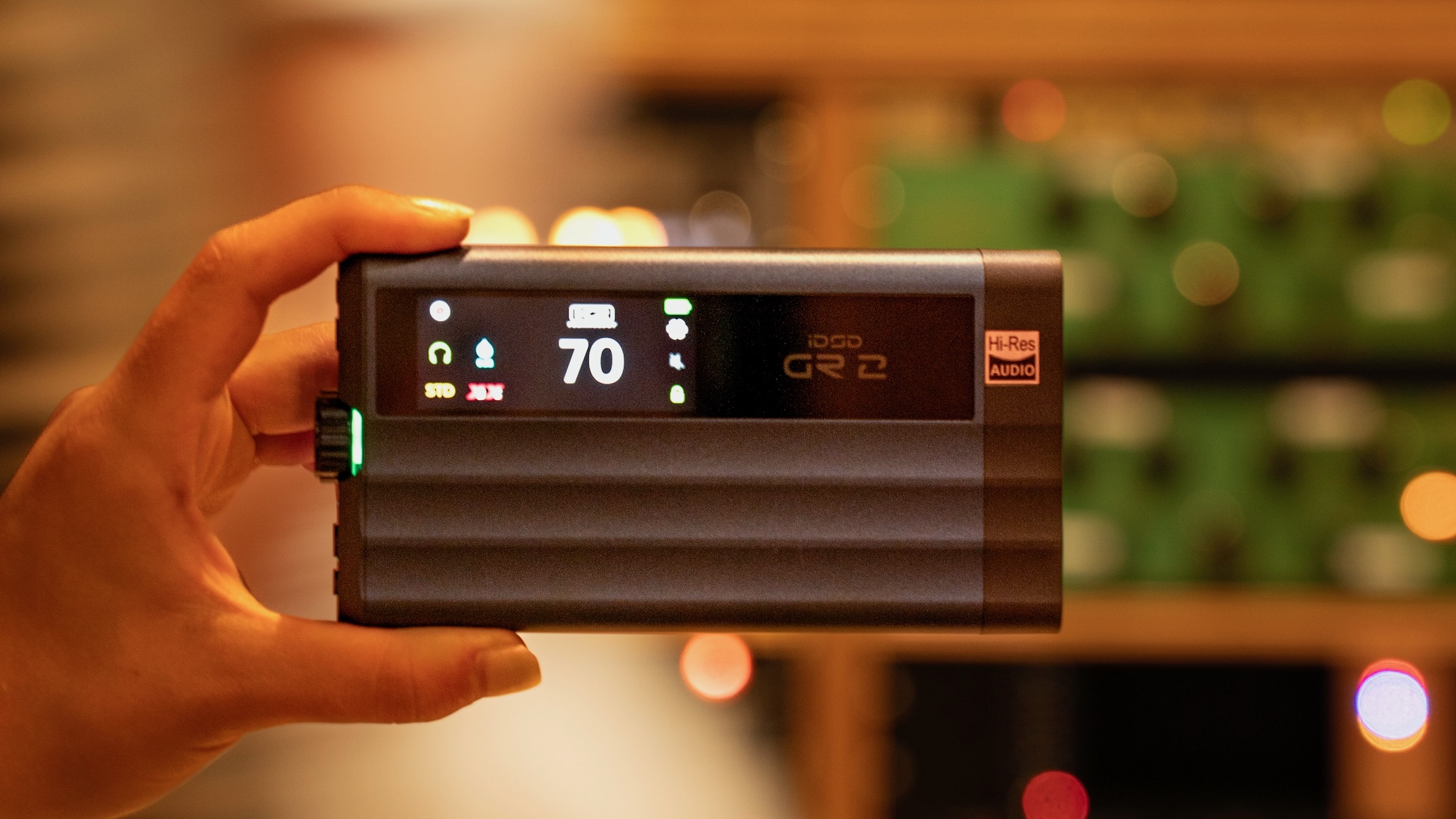 The iFi iDSD GR 2 being held in the foreground, with the background blurred.