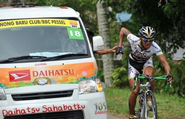 Agus Sofyan Ziad (Binong Baru Club-Indonesia) is grabbing the mineral water from official in the team car in stage 2 Tour de Singkarak 2012.