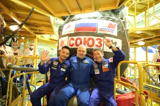 Japanese billionaire Yusaku Maezawa (right) poses for a crew photo with his video producer Yozo Hirano and Russian cosmonaut Alexander Misurkin during training to launch on a Soyuz spacecraft to the International Space Station. liftoff is set for Dec. 8. 