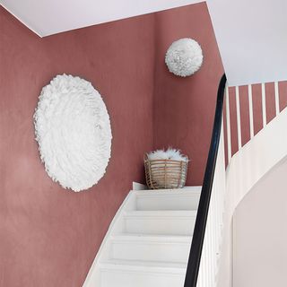 White staircase with red walls and white pompom lights
