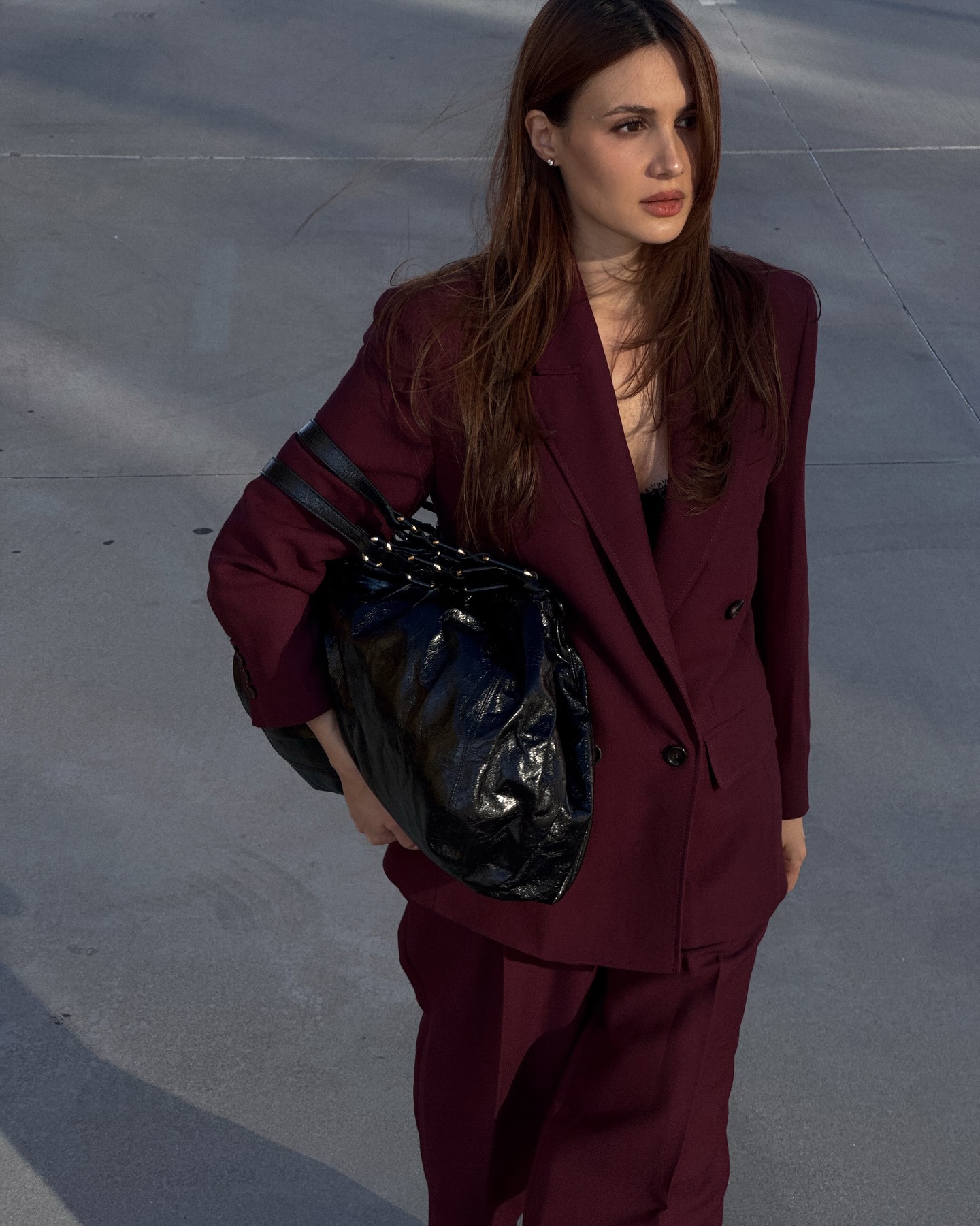 borislava sekova wears a burgundy suit and black bag
