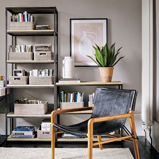 Beige living room with open shelving for books and a Scandi-style armchair