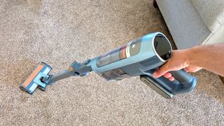 Person cleaning carpet with Shark PowerDetect Speed vacuum cleaner
