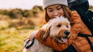 woman spending quality time outdoors hugging dog