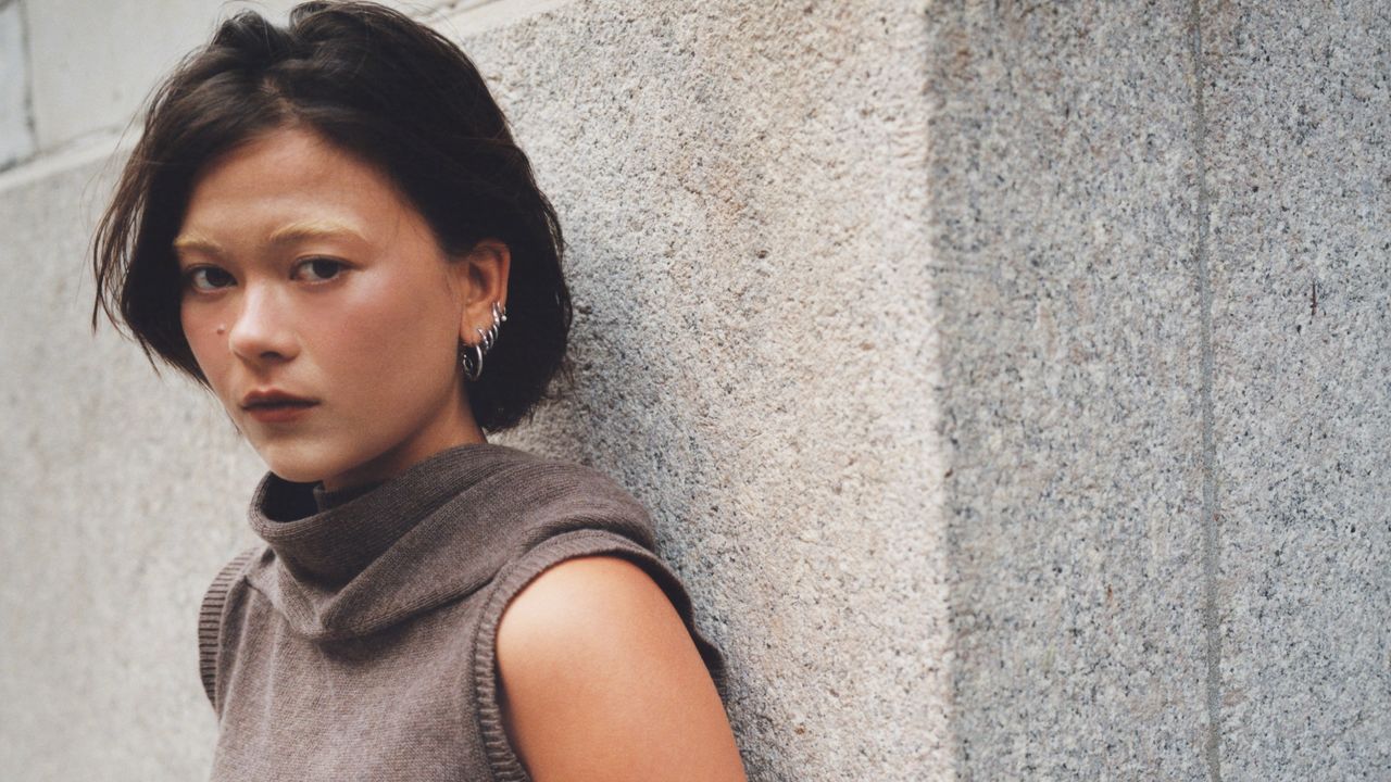 Actress Lukita Maxwell poses against a gray cement wall.