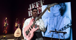 An auctioneer holds Jeff Beck's 'Tina' pink Jackson Soloist as it prepares to go under the hammer at Christie's in London