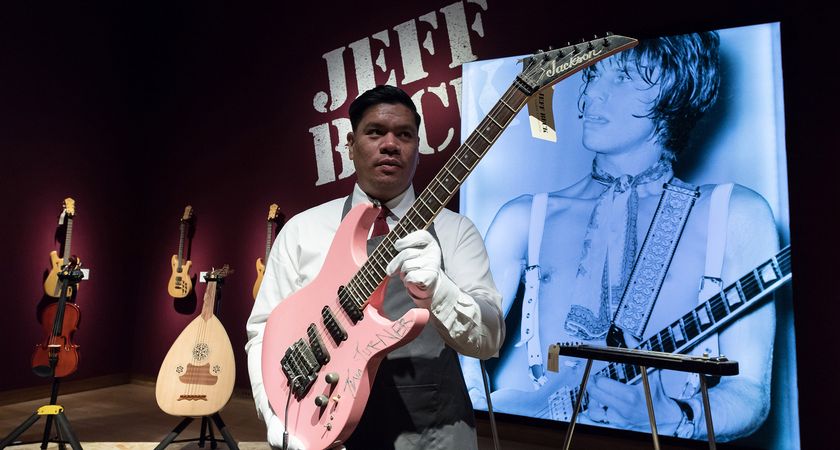 An auctioneer holds Jeff Beck's 'Tina' pink Jackson Soloist as it prepares to go under the hammer at Christie's in London