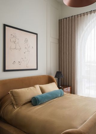 A bedroom with a mustard bed and a wood nightstand