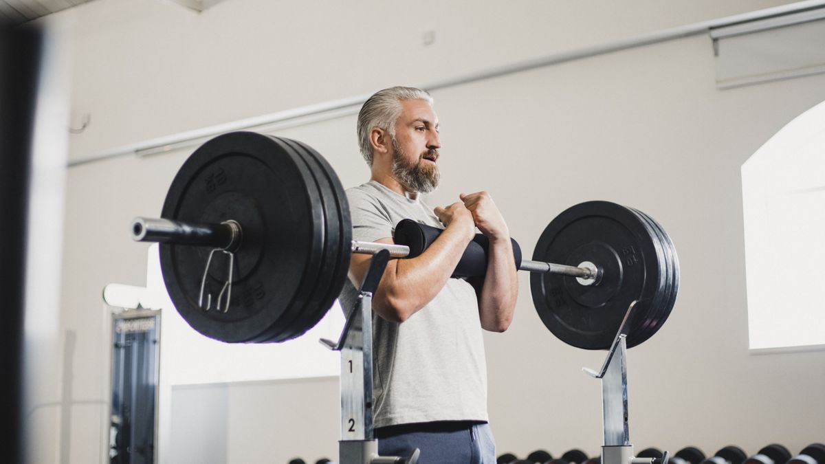 a photo of a man doing a zercher squat