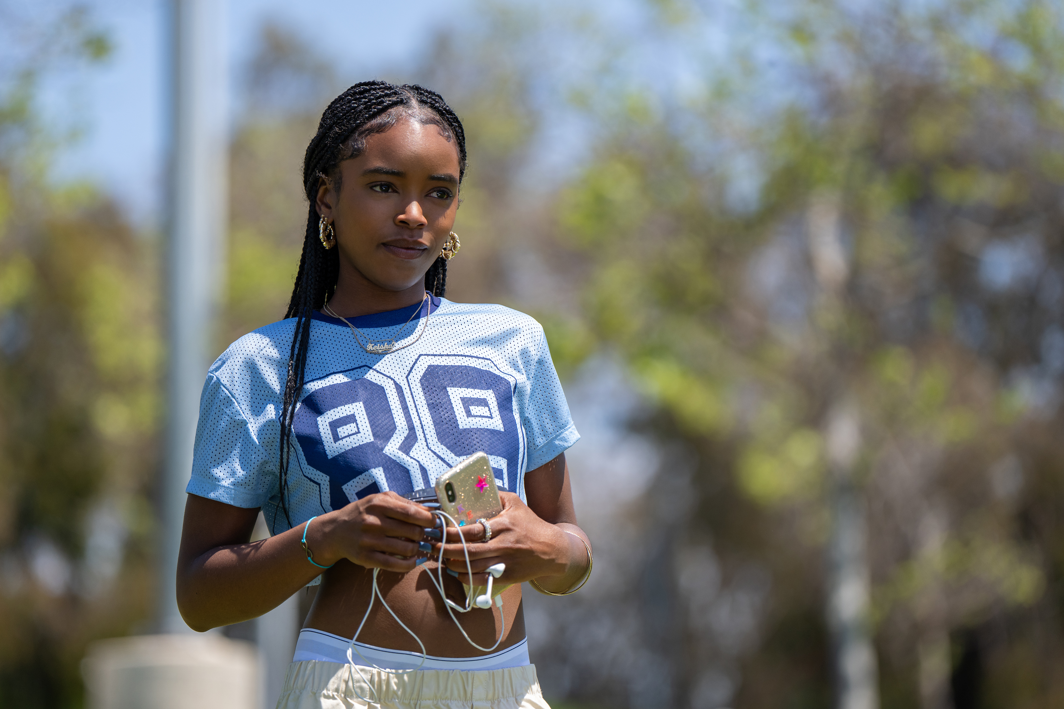 lovie simone as keisha clark wearing a jersey and holding her iphone and headphones in forever